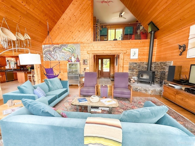 273 N Basin Dr, Negaunee, MI 49866 - living area with high vaulted ceiling, a wood stove, wood walls, wood finished floors, and wooden ceiling
