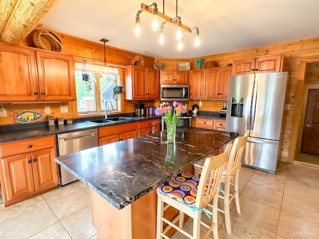273 N Basin Dr, Negaunee, MI 49866 - kitchen with stainless steel appliances, light tile patterned floors, brown cabinets, a kitchen island, and wood walls