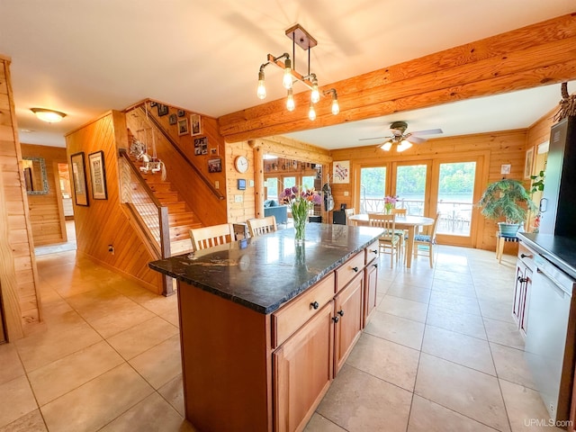 273 N Basin Dr, Negaunee, MI 49866 - kitchen featuring wooden walls, a ceiling fan, beam ceiling, a kitchen island, and light tile patterned floors