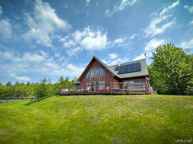 273 N Basin Dr, Negaunee, MI 49866 - back of house with roof mounted solar panels, a wooden deck, and roof with shingles
