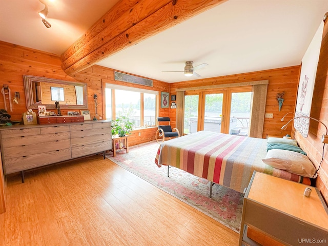 273 N Basin Dr, Negaunee, MI 49866 - bedroom featuring multiple windows, wood walls, wood finished floors, access to exterior, and a ceiling fan