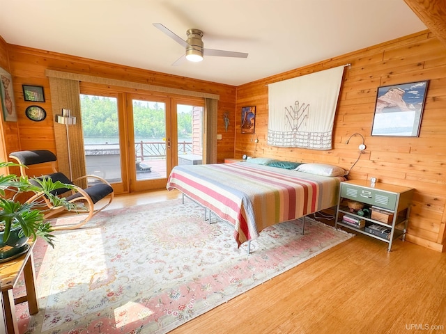273 N Basin Dr, Negaunee, MI 49866 - bedroom featuring french doors, wood walls, access to exterior, wood finished floors, and a ceiling fan
