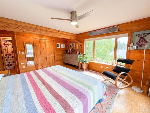 273 N Basin Dr, Negaunee, MI 49866 - bedroom featuring multiple windows, wood finished floors, wood walls, and ceiling fan
