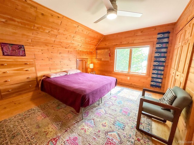 273 N Basin Dr, Negaunee, MI 49866 - bedroom with wooden walls, wood finished floors, vaulted ceiling, and a ceiling fan