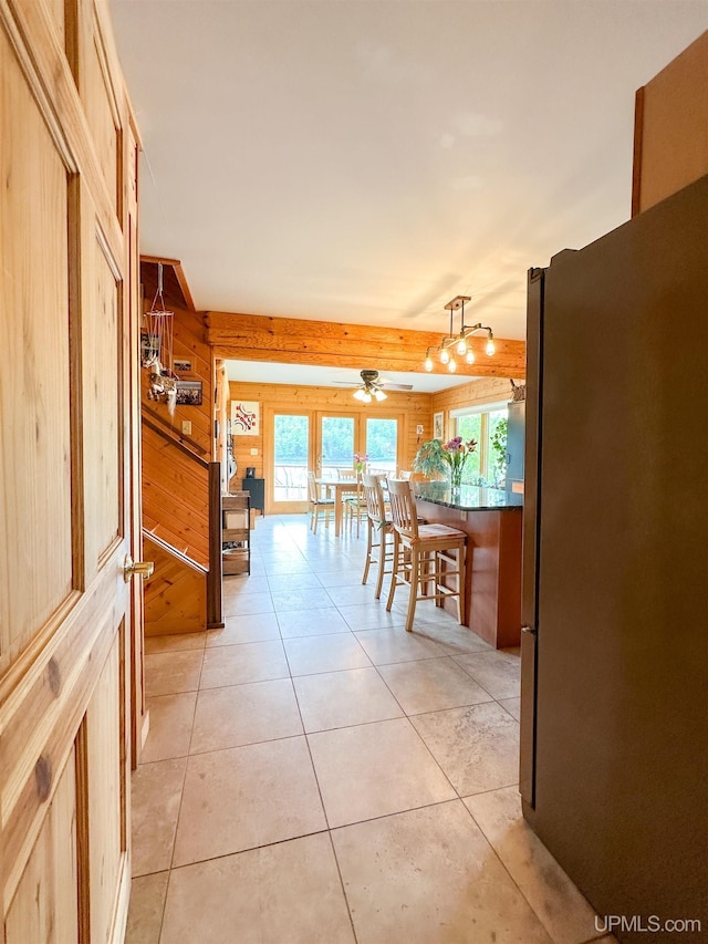 273 N Basin Dr, Negaunee, MI 49866 - dining area featuring light tile patterned floors, wood walls, and ceiling fan