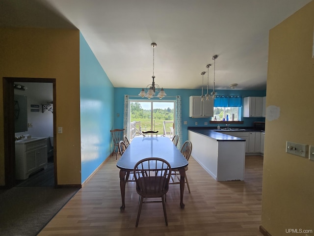 49962 Rosenlund Rd, Hancock, MI 49930 - dining room featuring wood finished floors, a chandelier, healthy amount of natural light, and vaulted ceiling