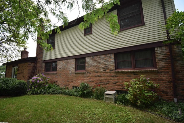 71800 Coon Creek Rd, Armada, MI 48005 - view of home's exterior with brick siding, a lawn, and a chimney