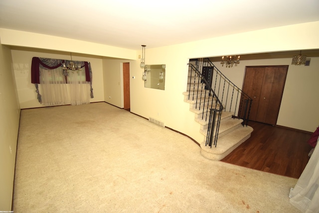 71800 Coon Creek Rd, Armada, MI 48005 - unfurnished room featuring a chandelier, stairway, carpet flooring, and wood finished floors