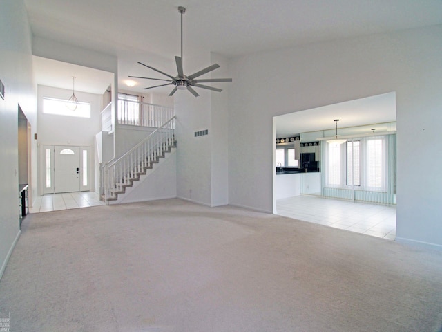 20343 Nicol Creek Dr, Macomb Twp, MI 48044 - unfurnished living room with carpet floors, stairs, a ceiling fan, and tile patterned flooring