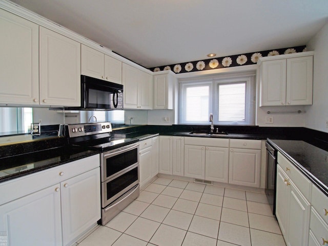 20343 Nicol Creek Dr, Macomb Twp, MI 48044 - kitchen with double oven range, black microwave, white cabinets, and light tile patterned floors