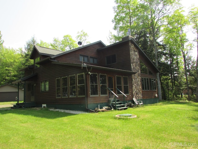 20517 Park Rd, Skanee, MI 49962 - back of house with entry steps, a yard, an outbuilding, and a chimney