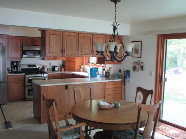 20517 Park Rd, Skanee, MI 49962 - kitchen with stainless steel appliances, light countertops, a peninsula, brown cabinets, and decorative light fixtures