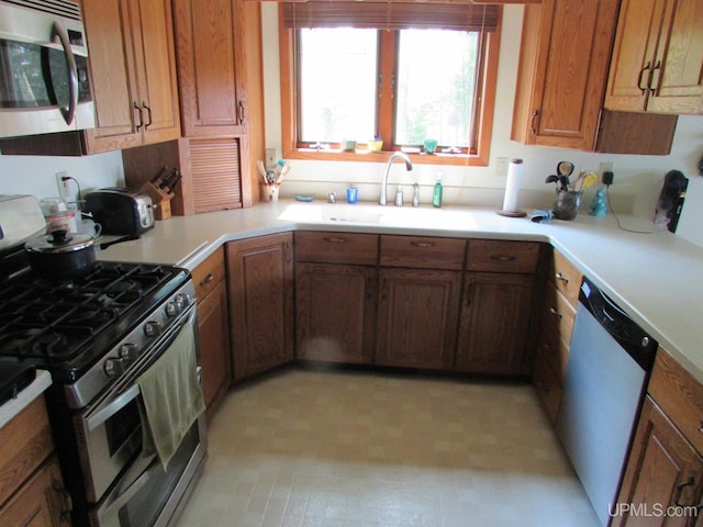 20517 Park Rd, Skanee, MI 49962 - kitchen featuring appliances with stainless steel finishes, brown cabinets, light countertops, and light floors