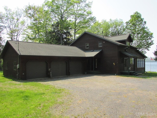 20517 Park Rd, Skanee, MI 49962 - view of front of home with dirt driveway, a shingled roof, and a garage