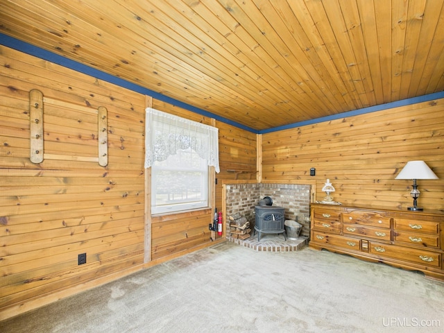 10031 N Ross Lake Rd, Shingleton, MI 49884 - unfurnished room featuring a wood stove, carpet flooring, wood ceiling, and wooden walls
