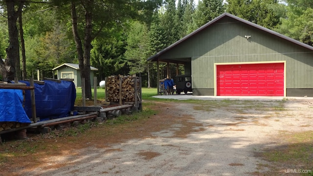 10031 N Ross Lake Rd, Shingleton, MI 49884 - view of property exterior featuring an outdoor structure, a garage, and driveway