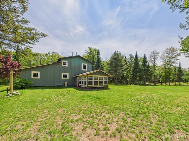 10031 N Ross Lake Rd, Shingleton, MI 49884 - rear view of property with a sunroom and a lawn