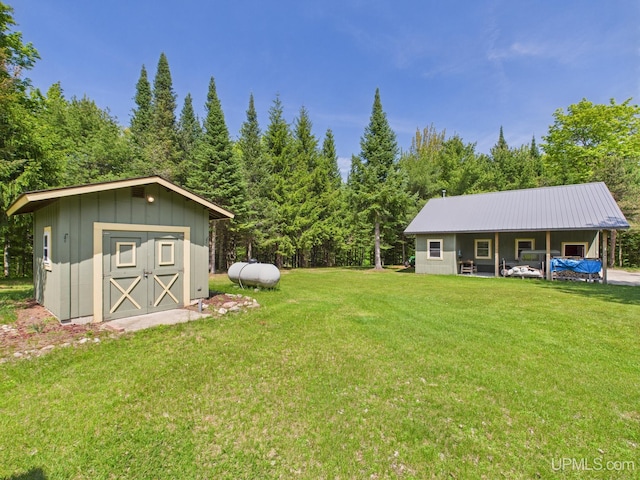 10031 N Ross Lake Rd, Shingleton, MI 49884 - view of grassy yard featuring a storage unit and a forest view