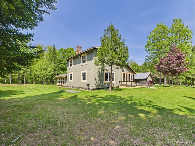 10031 N Ross Lake Rd, Shingleton, MI 49884 - rear view of property with a chimney, a lawn, and view of wooded area