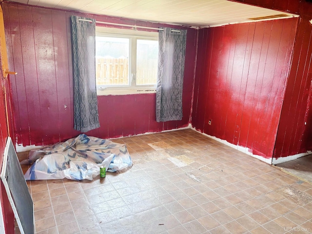 345 N Maple St, Manistique, MI 49854 - spare room with wooden walls and tile patterned floors