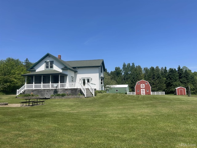 232 Winberg Rd, Skandia, MI 49885 - rear view of property featuring a chimney, a lawn, a barn, and a storage unit