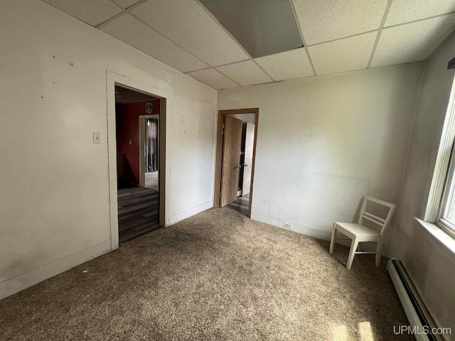 228 Schoolcraft Ave, Manistique, MI 49854 - carpeted empty room featuring a baseboard radiator and a drop ceiling
