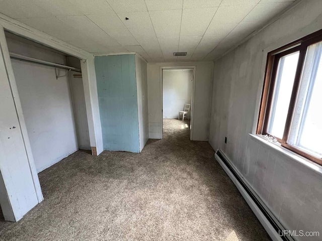 228 Schoolcraft Ave, Manistique, MI 49854 - unfurnished bedroom with a baseboard radiator, carpet flooring, and a closet
