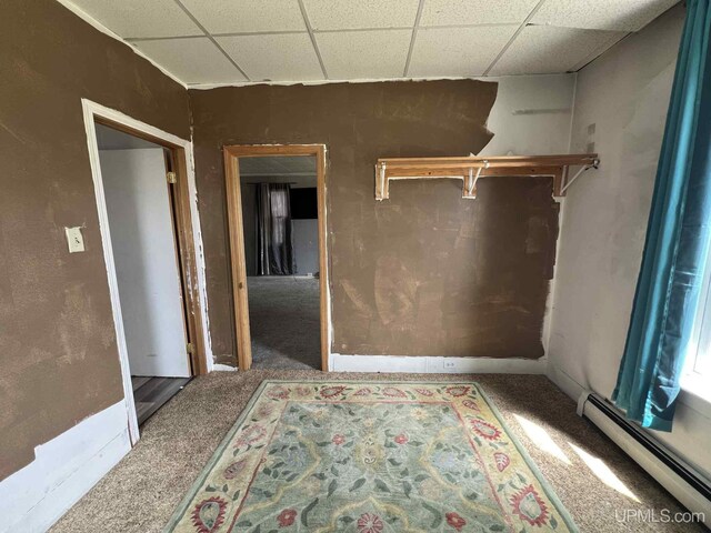 228 Schoolcraft Ave, Manistique, MI 49854 - unfurnished room featuring baseboard heating, a drop ceiling, and carpet flooring
