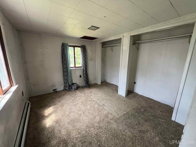 228 Schoolcraft Ave, Manistique, MI 49854 - unfurnished bedroom with multiple closets, baseboard heating, and carpet