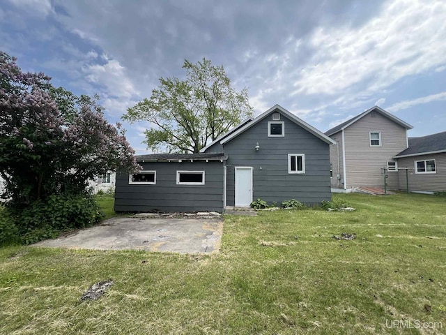 228 Schoolcraft Ave, Manistique, MI 49854 - back of house featuring a patio area and a lawn