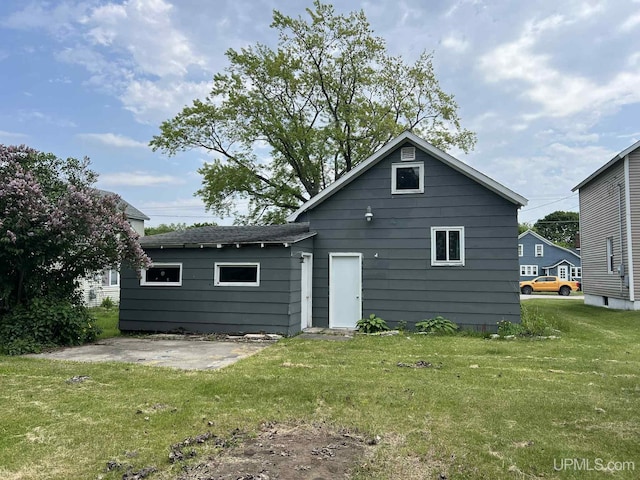 228 Schoolcraft Ave, Manistique, MI 49854 - back of property featuring a patio area and a yard