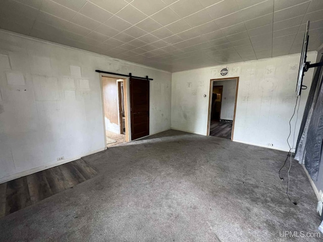 228 Schoolcraft Ave, Manistique, MI 49854 - spare room with a barn door and carpet flooring