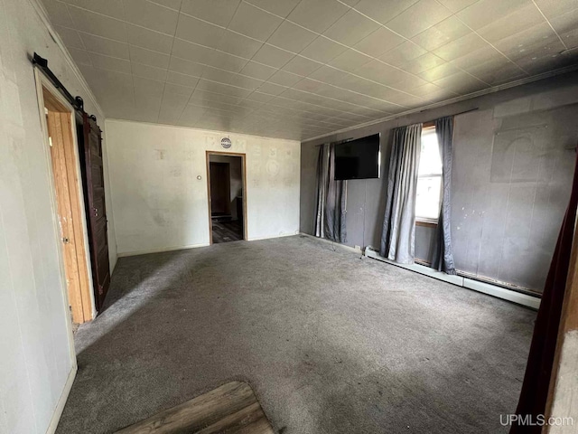 228 Schoolcraft Ave, Manistique, MI 49854 - carpeted spare room featuring a barn door and a baseboard heating unit