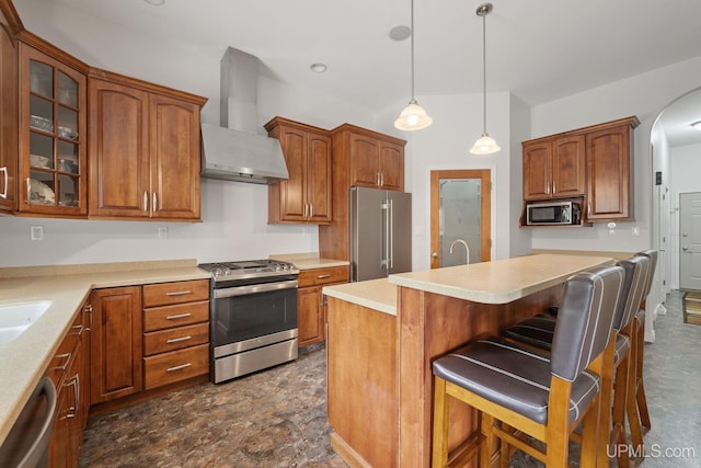 821 Camelot Dr, Negaunee, MI 49866 - kitchen featuring wall chimney exhaust hood, appliances with stainless steel finishes, a breakfast bar area, glass insert cabinets, and light countertops