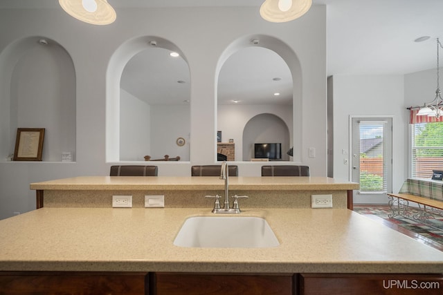 821 Camelot Dr, Negaunee, MI 49866 - kitchen with open floor plan, hanging light fixtures, recessed lighting, a center island with sink, and light stone counters