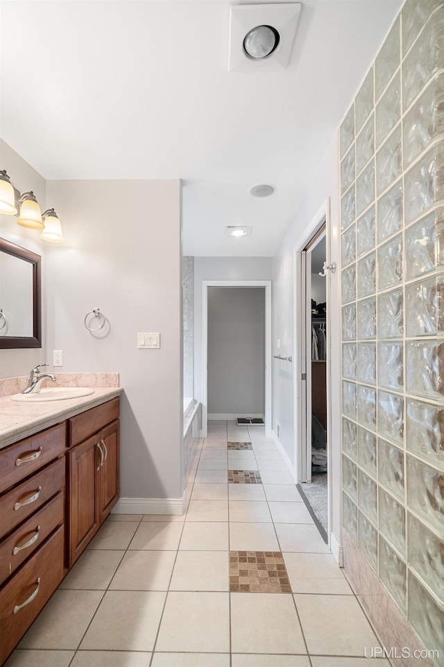 821 Camelot Dr, Negaunee, MI 49866 - bathroom featuring vanity, a walk in closet, tile patterned flooring, and a shower
