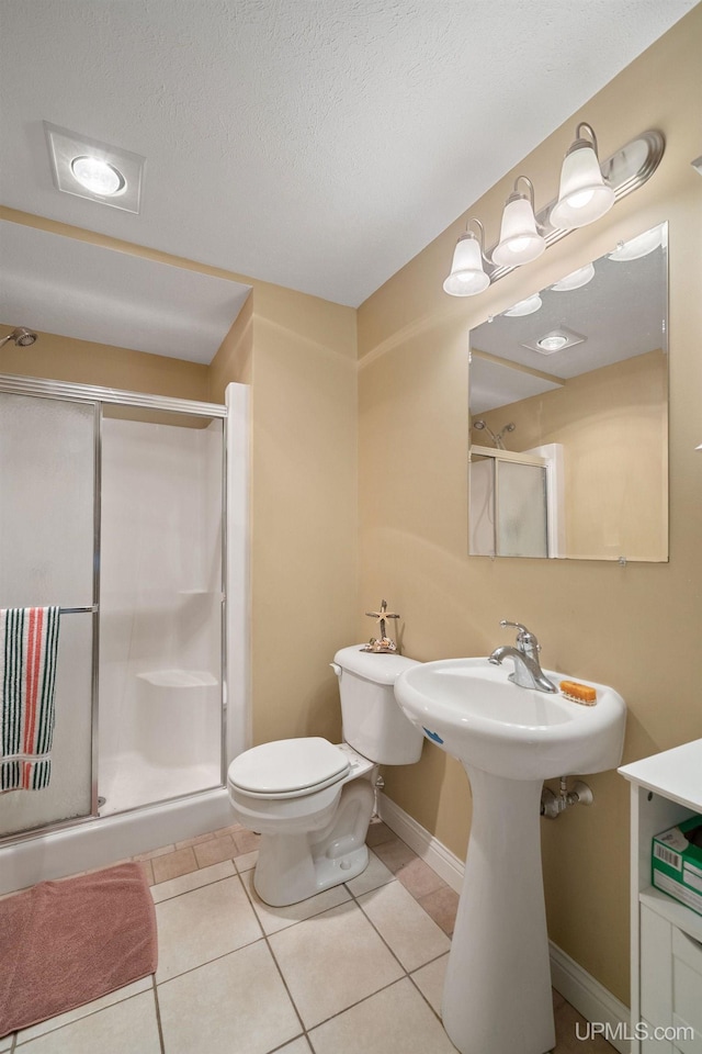 821 Camelot Dr, Negaunee, MI 49866 - bathroom with a shower stall, tile patterned floors, and a textured ceiling