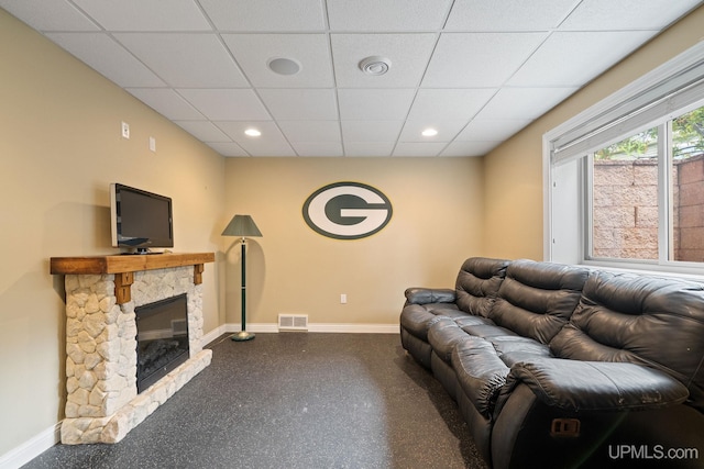821 Camelot Dr, Negaunee, MI 49866 - living room with a drop ceiling, a stone fireplace, speckle patterned floor, and recessed lighting