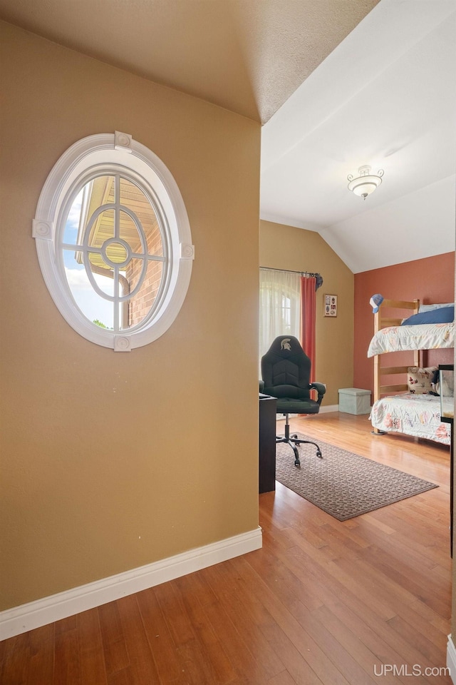 821 Camelot Dr, Negaunee, MI 49866 - bedroom with lofted ceiling and wood finished floors
