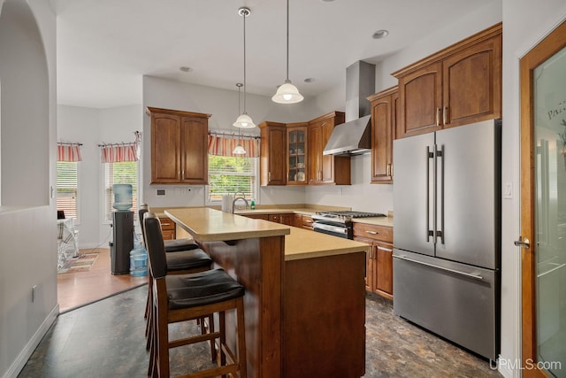 821 Camelot Dr, Negaunee, MI 49866 - kitchen with stainless steel appliances, light countertops, wall chimney range hood, glass insert cabinets, and a center island