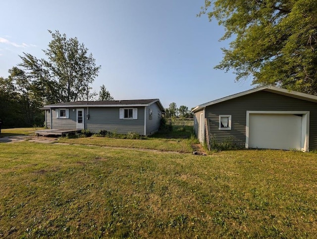 304 Beech St, Kawkawlin, MI 48706 - rear view of house featuring a lawn, a garage, and an outdoor structure