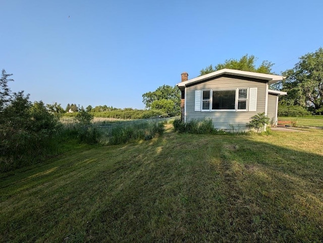 304 Beech St, Kawkawlin, MI 48706 - view of property exterior featuring a chimney and a yard