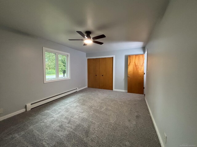 10301 County Farm Rd, Parma, MI 49269 - unfurnished bedroom with baseboard heating, carpet, a closet, and a ceiling fan