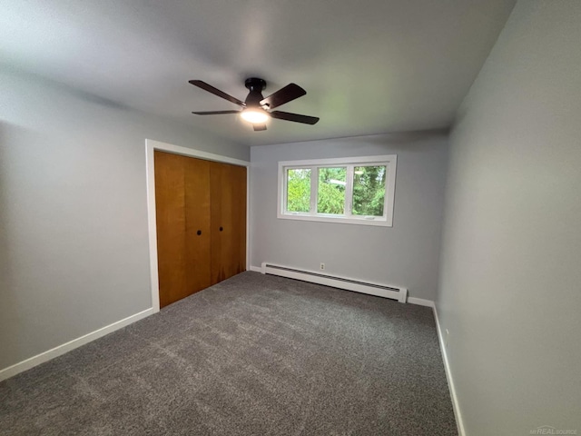 10301 County Farm Rd, Parma, MI 49269 - unfurnished bedroom featuring a baseboard radiator, a closet, dark colored carpet, and ceiling fan