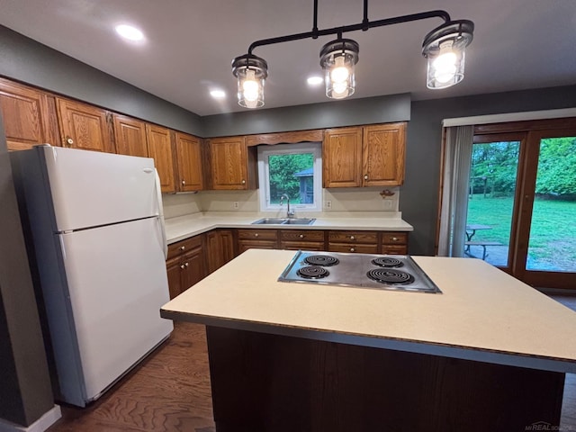 10301 County Farm Rd, Parma, MI 49269 - kitchen with freestanding refrigerator, stainless steel electric stovetop, light countertops, brown cabinetry, and recessed lighting