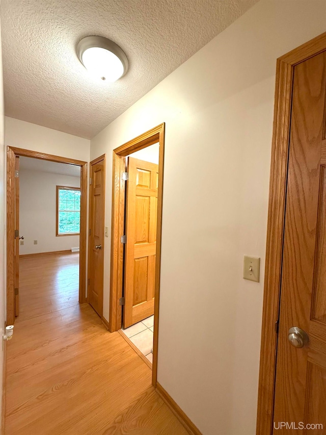 2003 Spruce Ln, Houghton, MI 49931 - corridor featuring light wood-type flooring and a textured ceiling