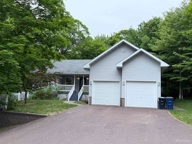 2003 Spruce Ln, Houghton, MI 49931 - view of front of house with driveway, covered porch, a garage, a shingled roof, and a front lawn