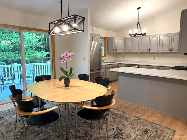 2003 Spruce Ln, Houghton, MI 49931 - dining space featuring a chandelier, light wood-style floors, healthy amount of natural light, and vaulted ceiling