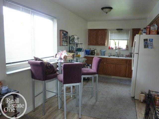 20127 14 Mile Rd, Clinton Township, MI 48035 - kitchen featuring freestanding refrigerator, light countertops, and brown cabinets