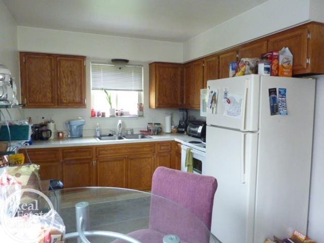 20127 14 Mile Rd, Clinton Township, MI 48035 - kitchen with white appliances, light countertops, and brown cabinetry